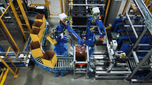 Robotic arms automatically pack medical isotopes on an assembly line.