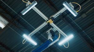 A cobot with vision capabilities hangs above an assembly line.